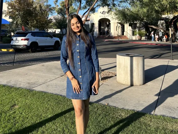 Kargi, an Arizona Senior standing in front of a restaurant in Tucson