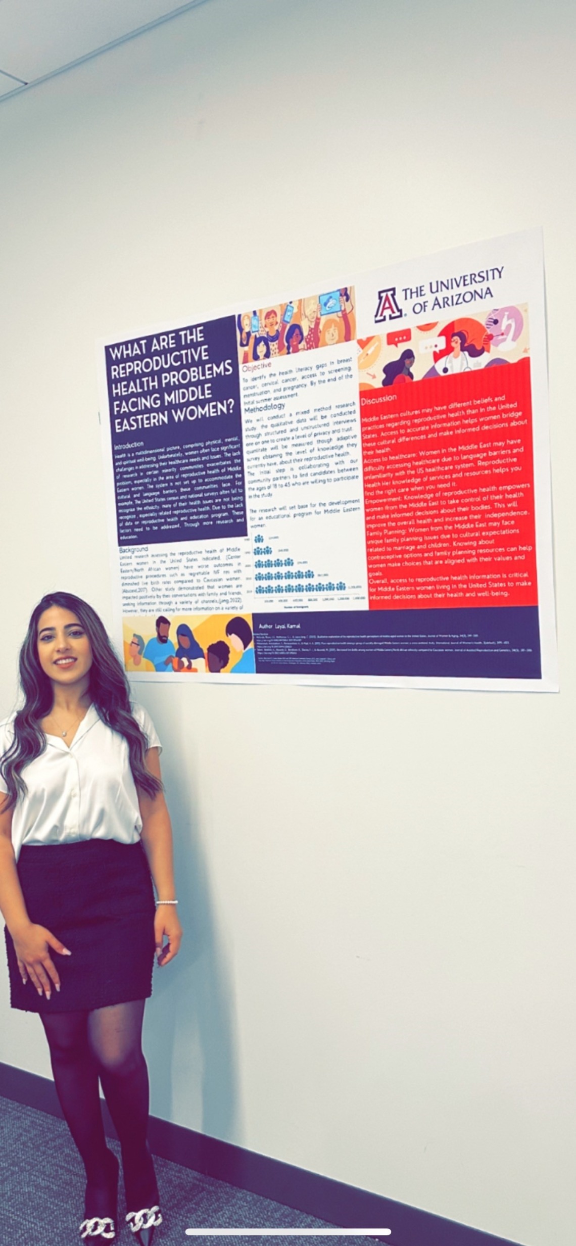 Layal- Standing in front of her academic poster. 