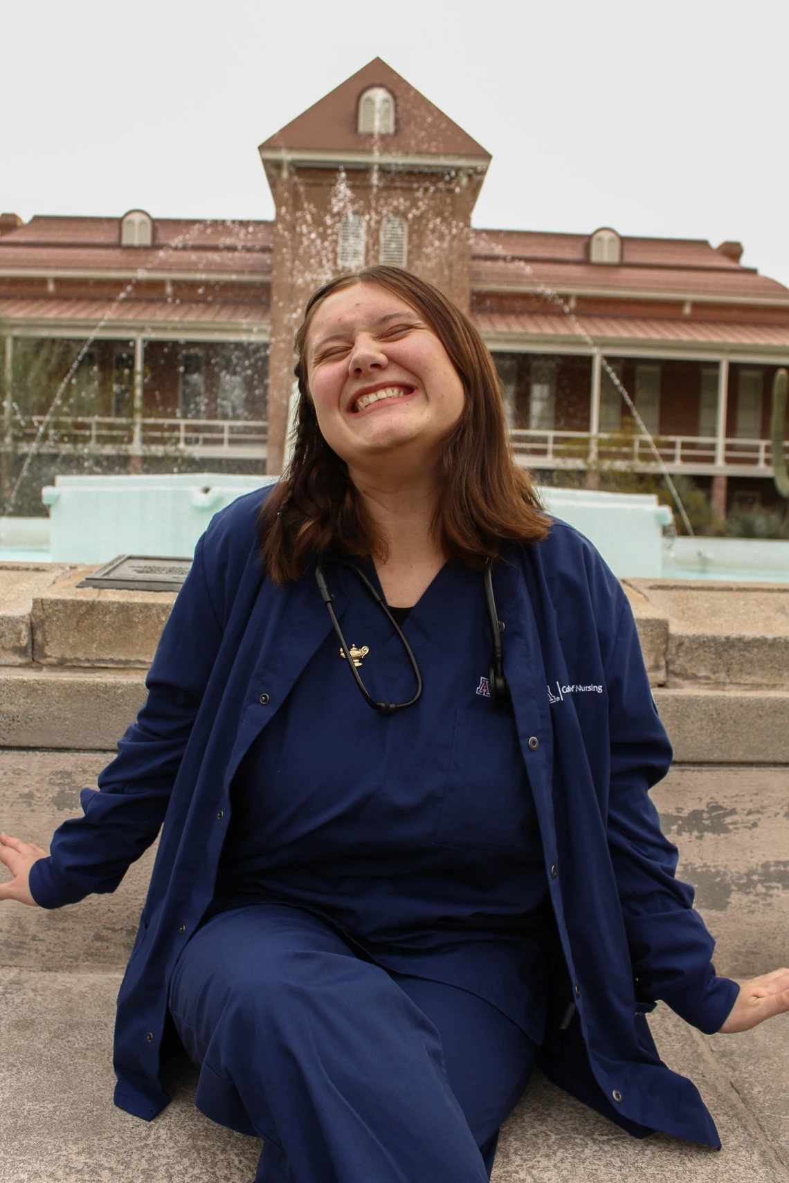 Student Bree Lynn, smiling in front of the fountain at Old Main 